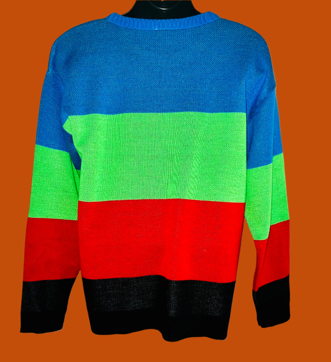 Color-blocked sweater with blue, green, red, and black sections on a white background