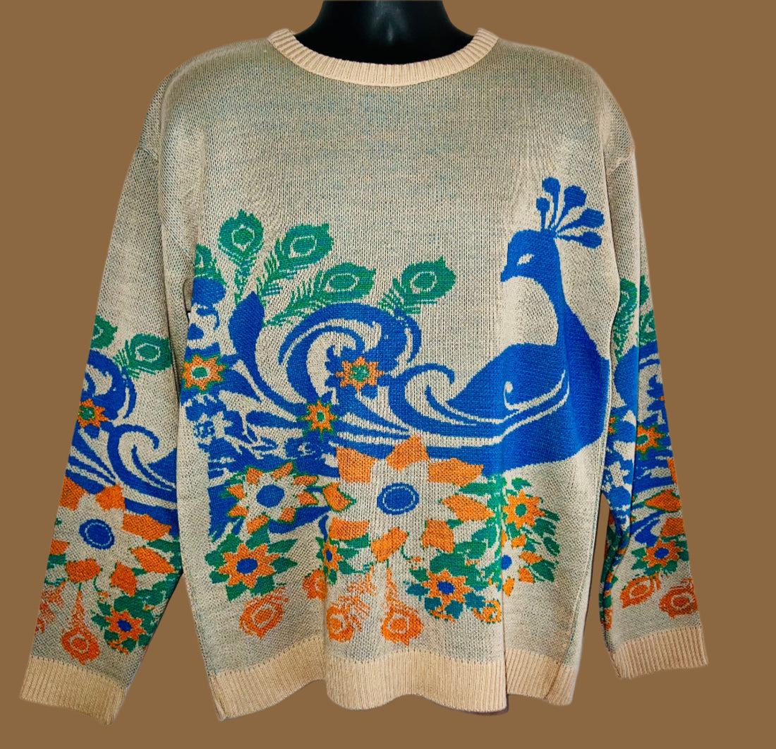 Beige sweater with blue peacock design on a white background