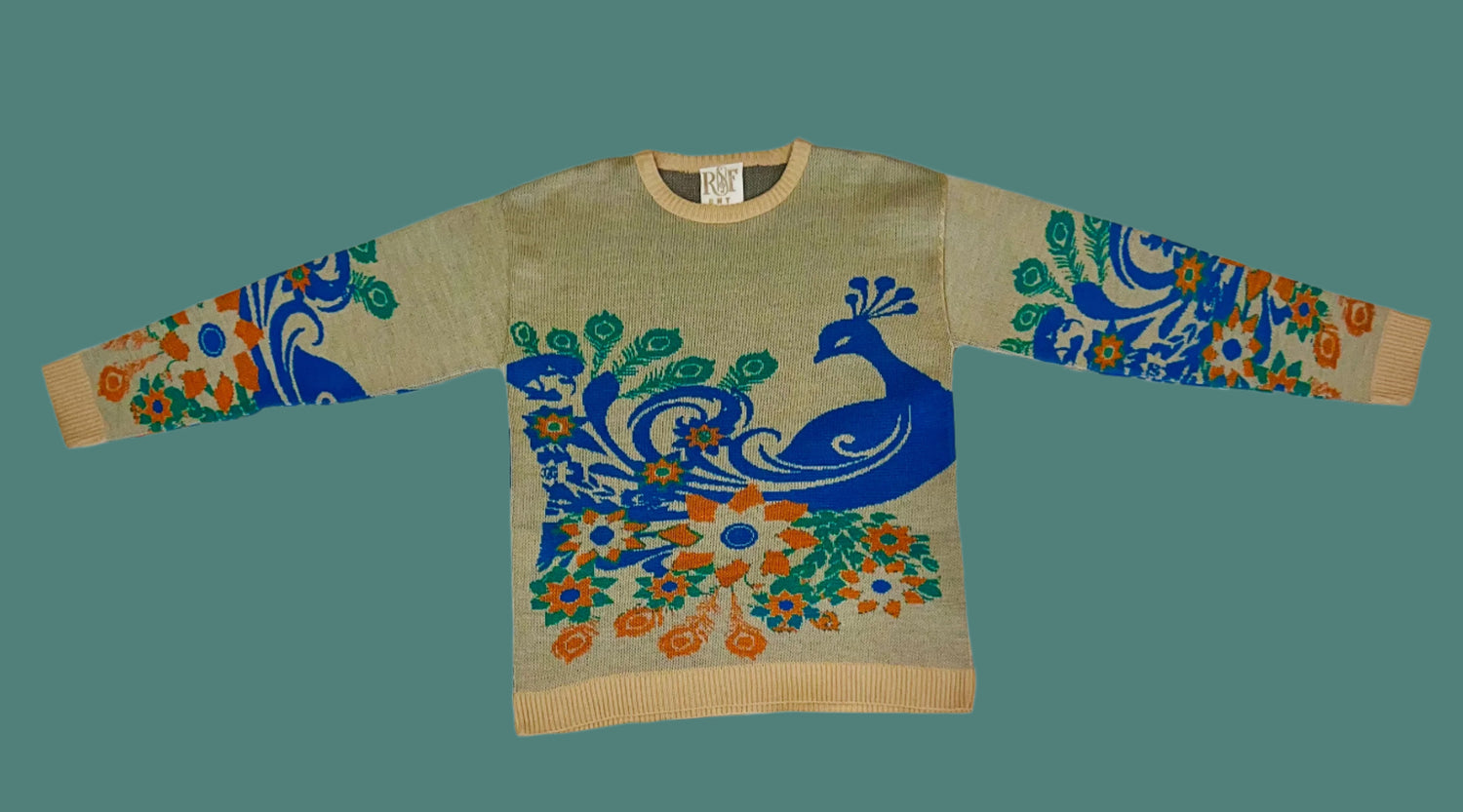 Sweater with peacock design on a white fabric background