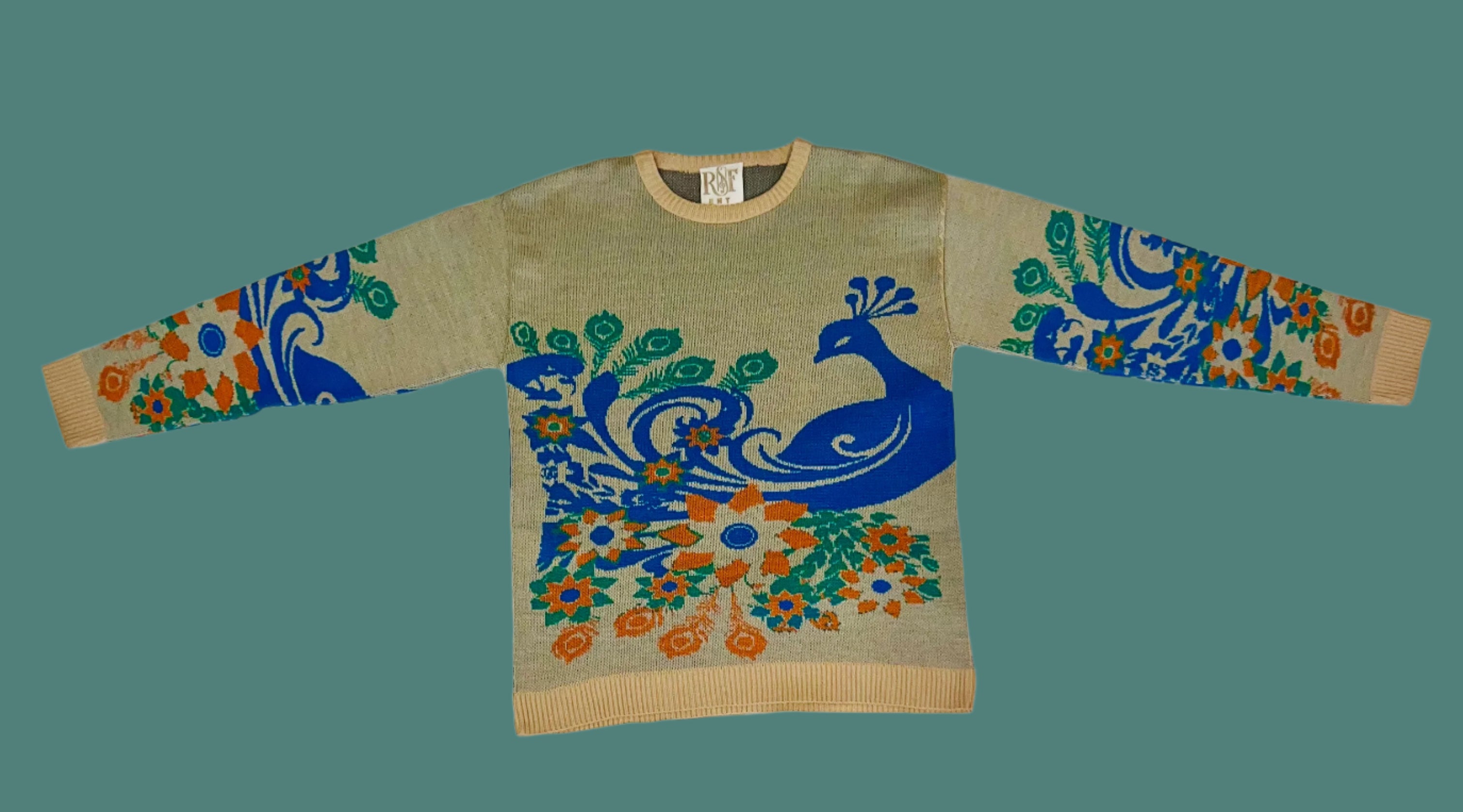 Sweater with peacock design on a white fabric background