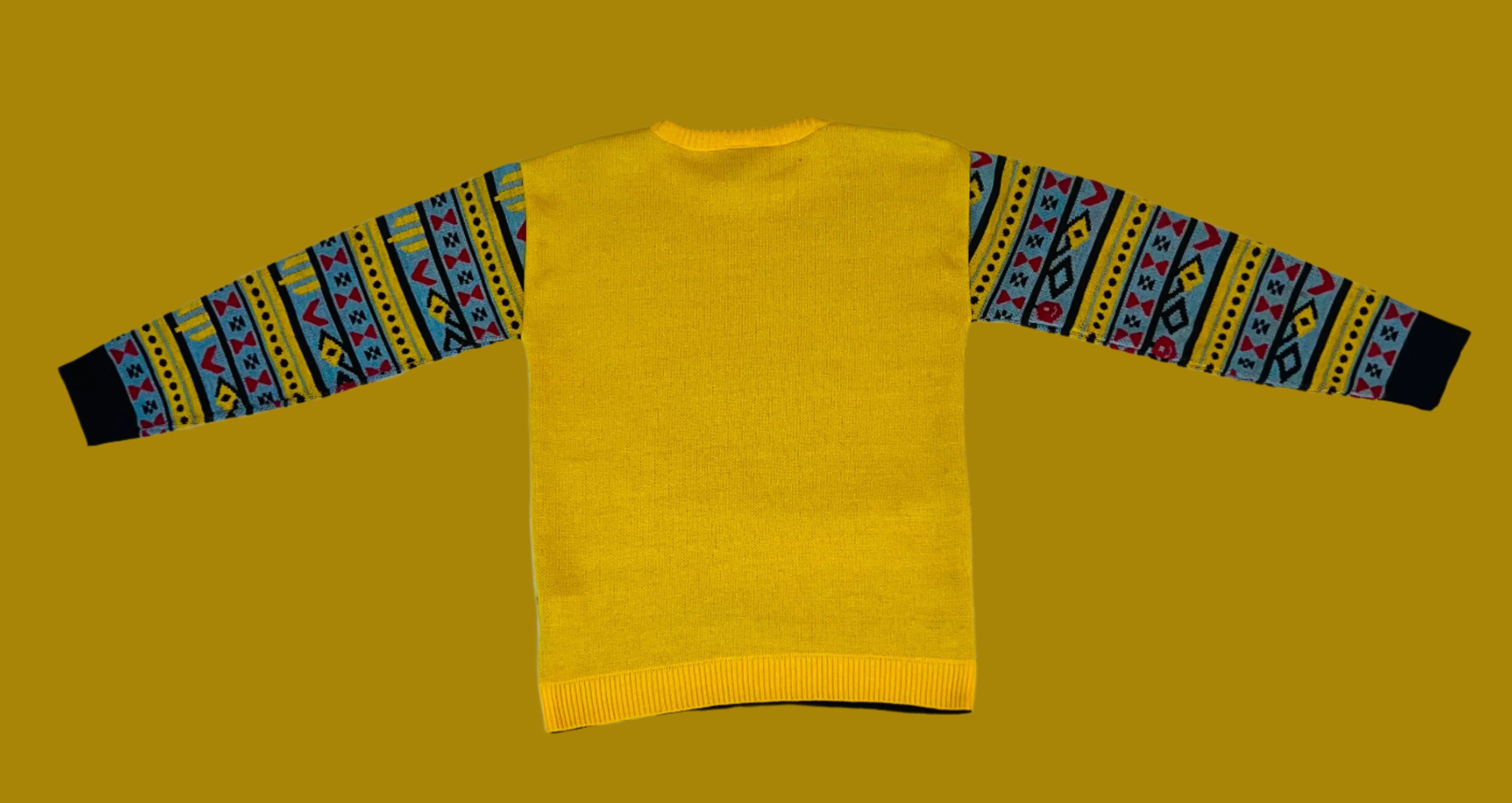 Yellow sweater with patterned sleeves on a white fabric background